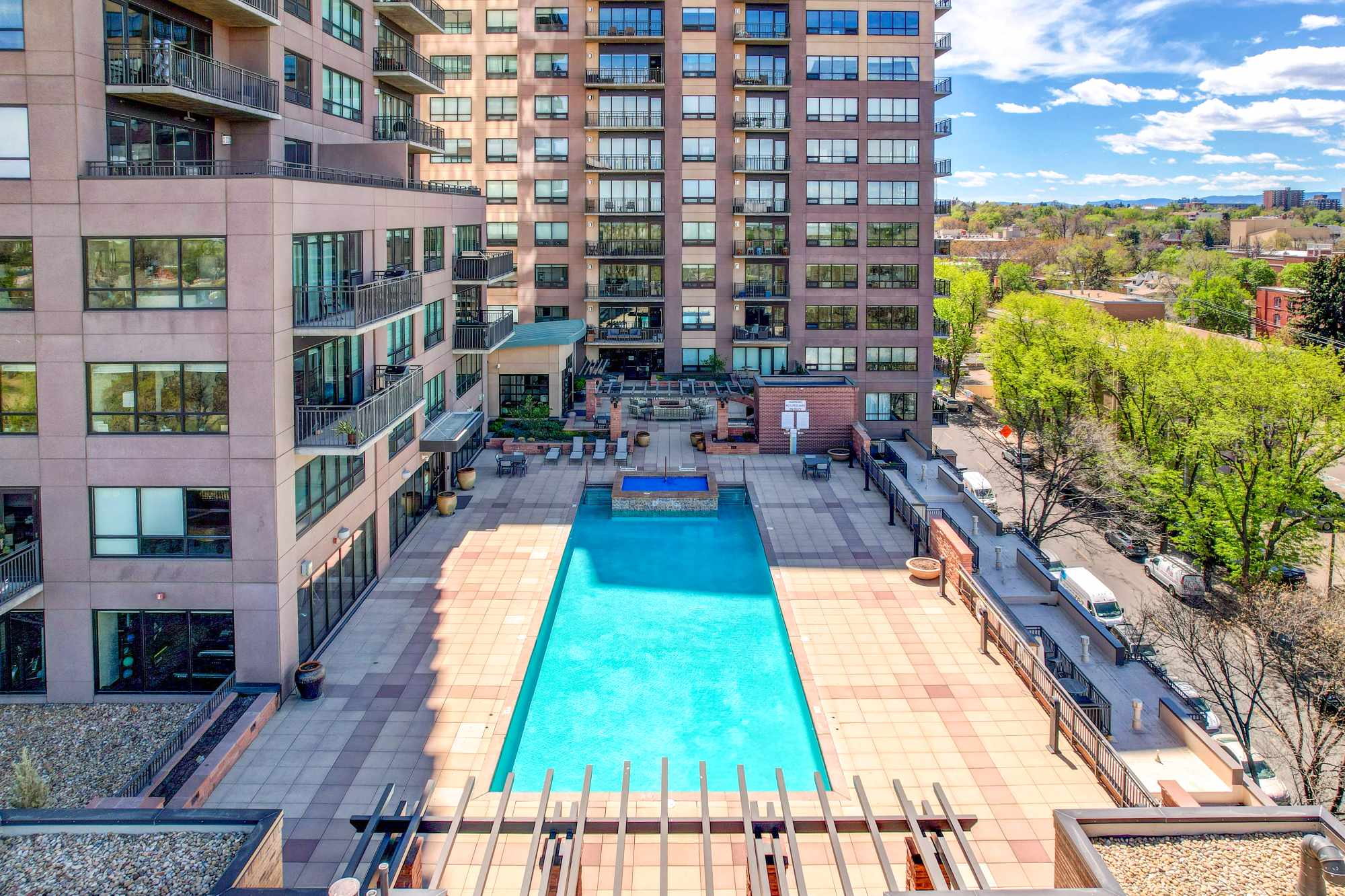 Elevated view of a high-rise condo building's pool deck and amenity terrace
